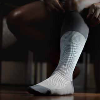 Grey houndstooth dress socks worn, highlighting premium fit and design.