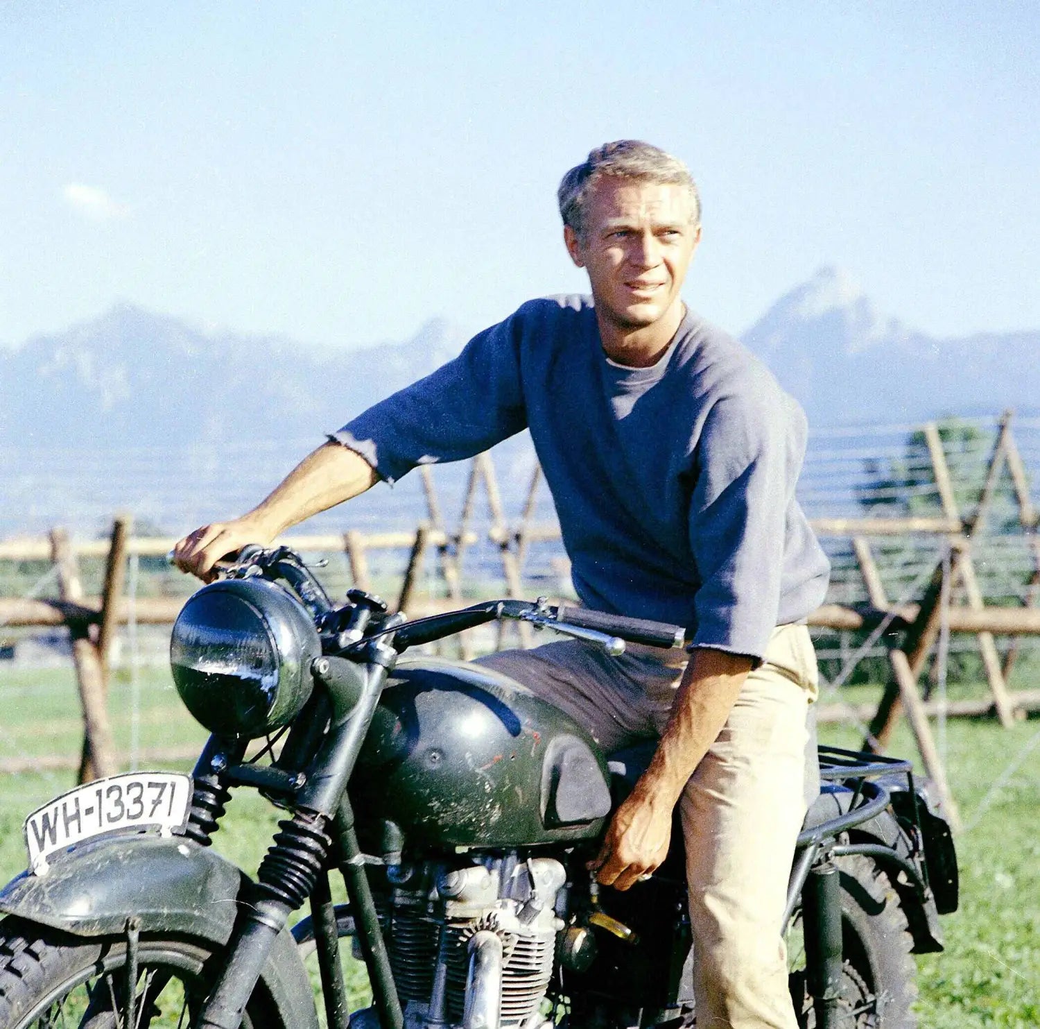 Vintage motorcycle with Steve McQueen showcasing iconic men’s summer outfits style