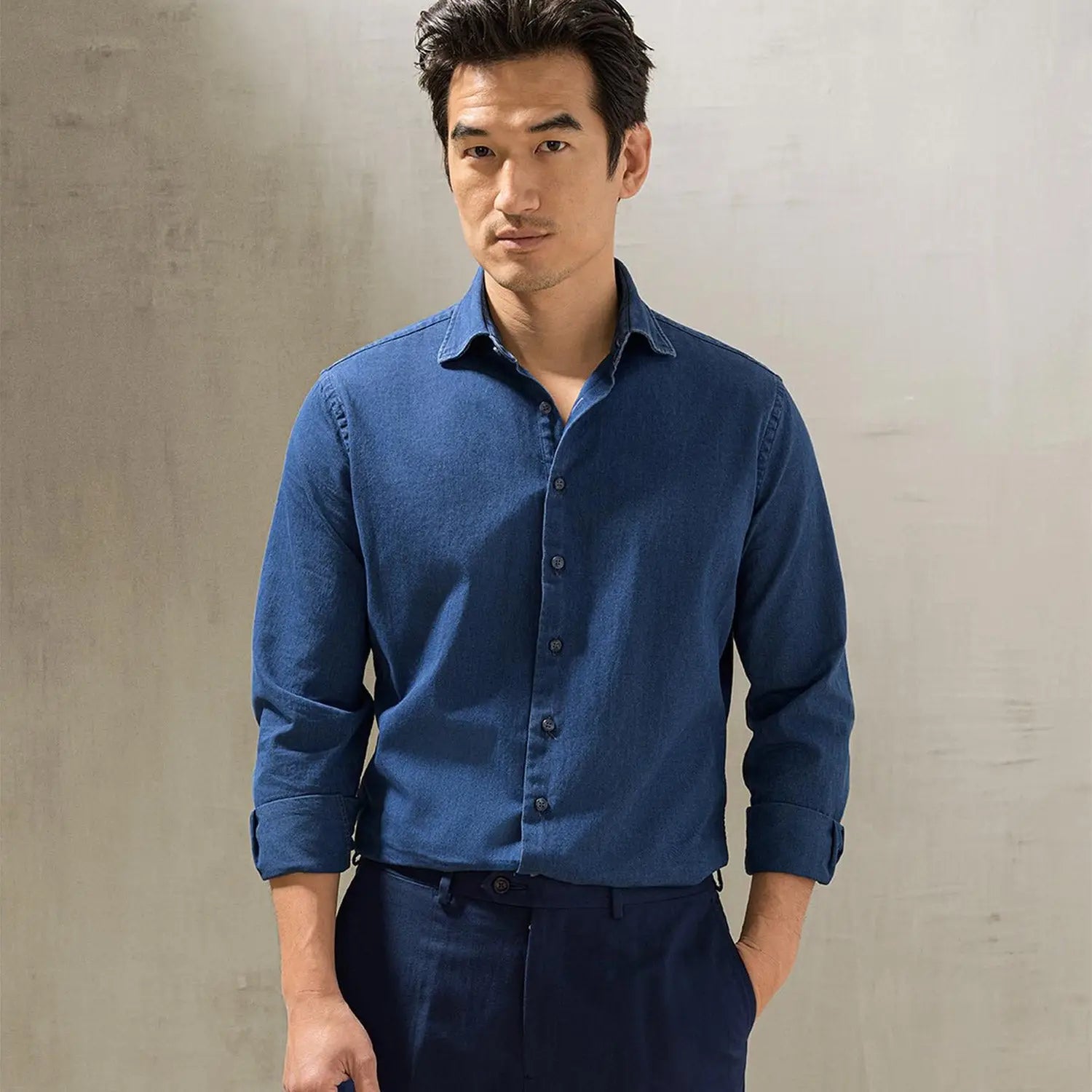 Man in a blue button-down shirt showcasing stylish office outfits to stay cool and confident