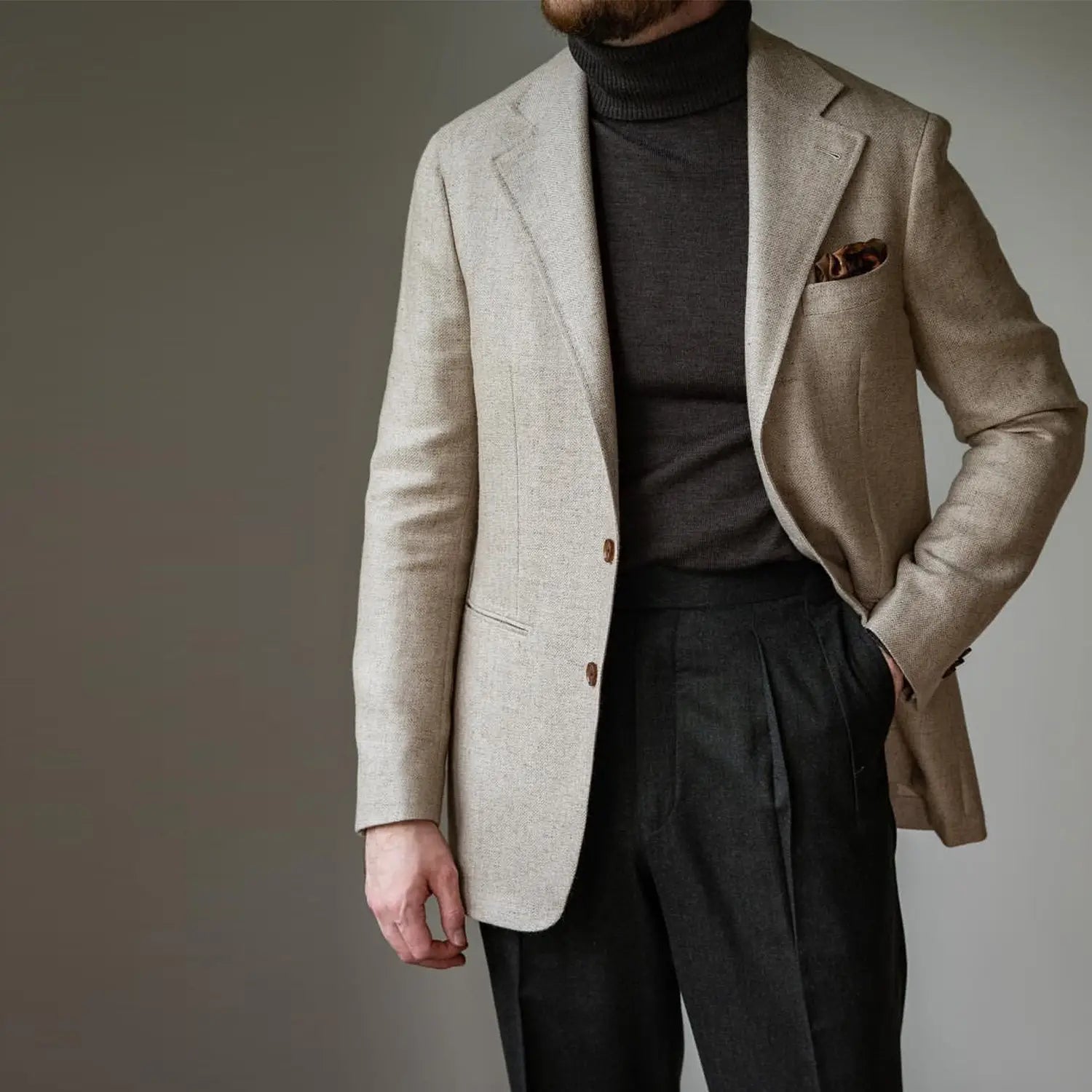 Man in beige blazer and black turtleneck showcasing timeless style with high-quality clothes
