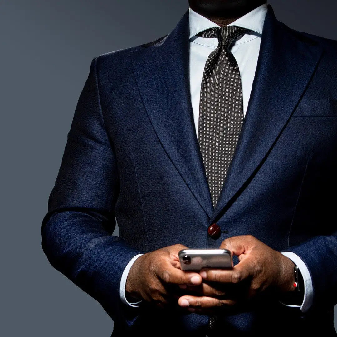 man in a suit holding phone showcasing timeless style and high-quality clothes