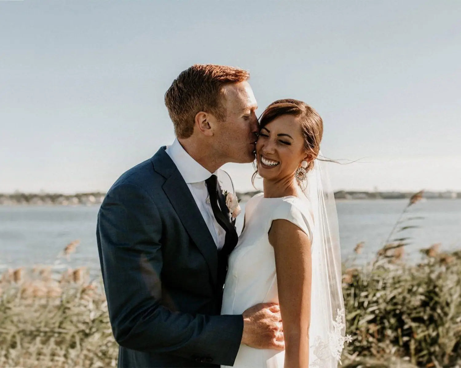 Newlyweds embracing on wedding day, showcasing stylish wedding suit and dress shirt