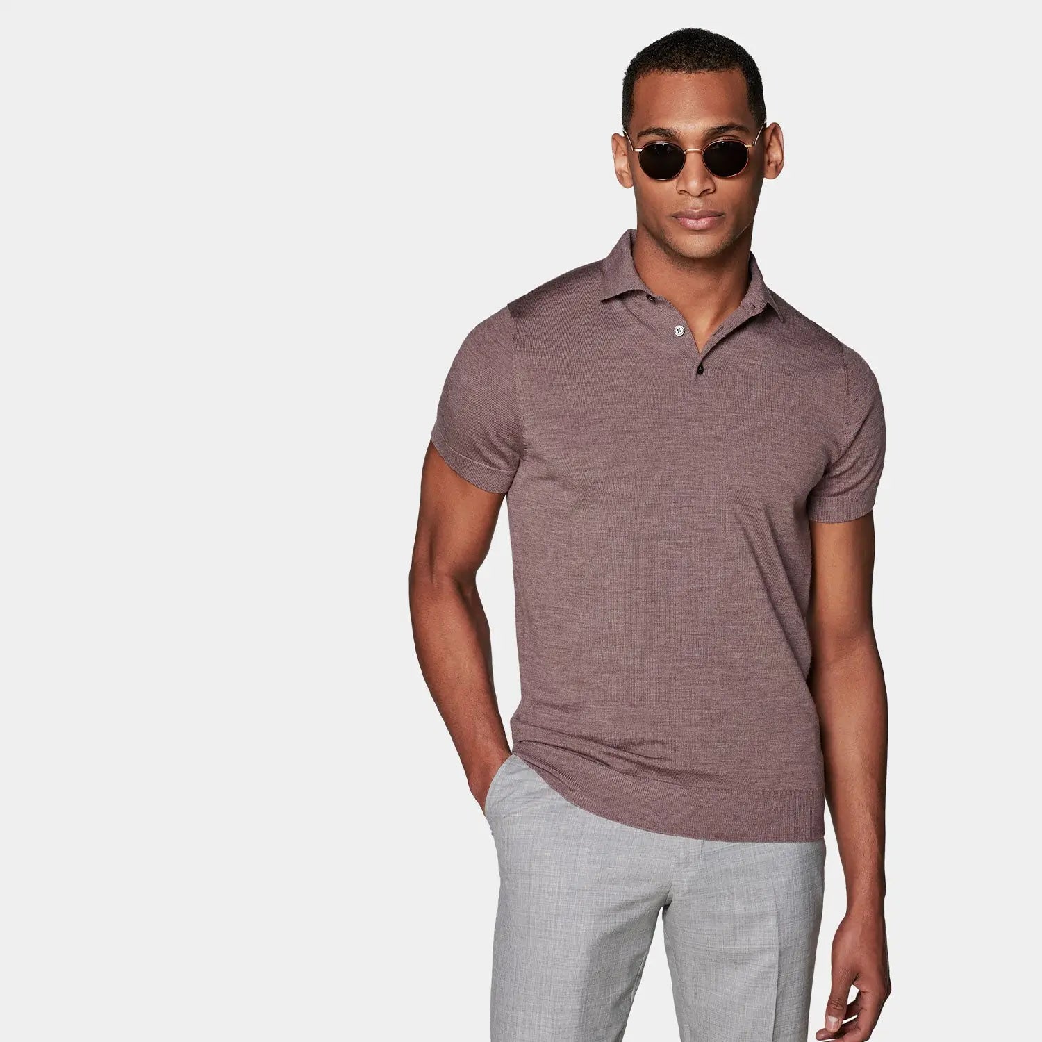 Man in brown polo shirt and gray pants highlighting small details for systems check on poor outfit