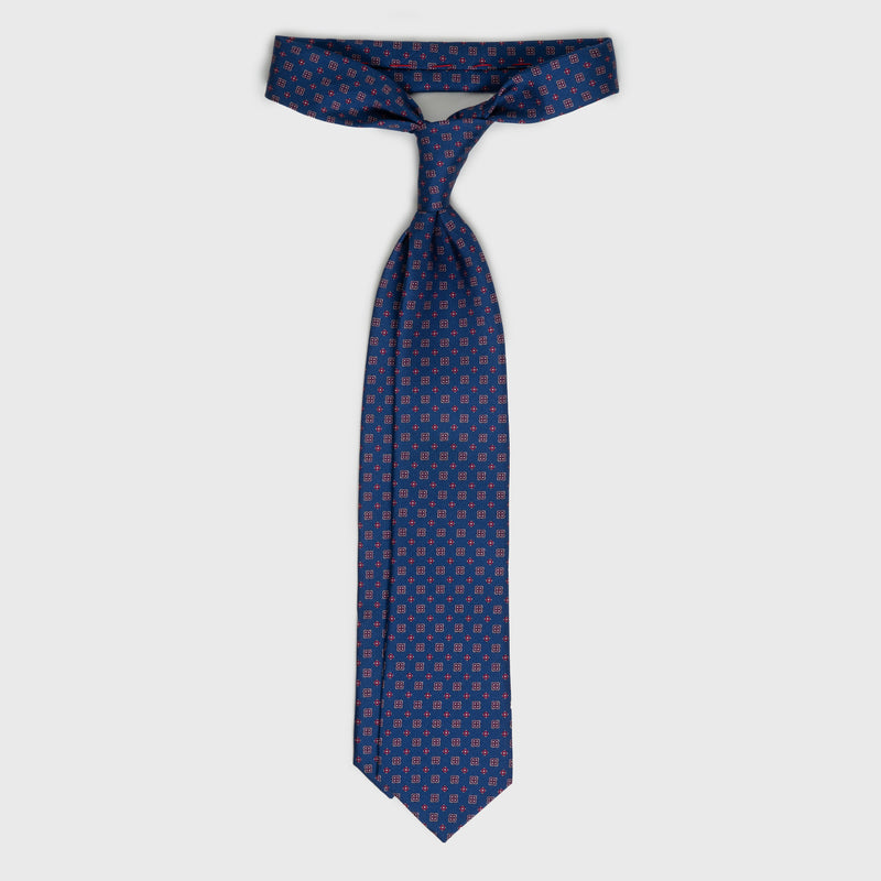 Royal blue floral foulard printed silk tie displayed untied.