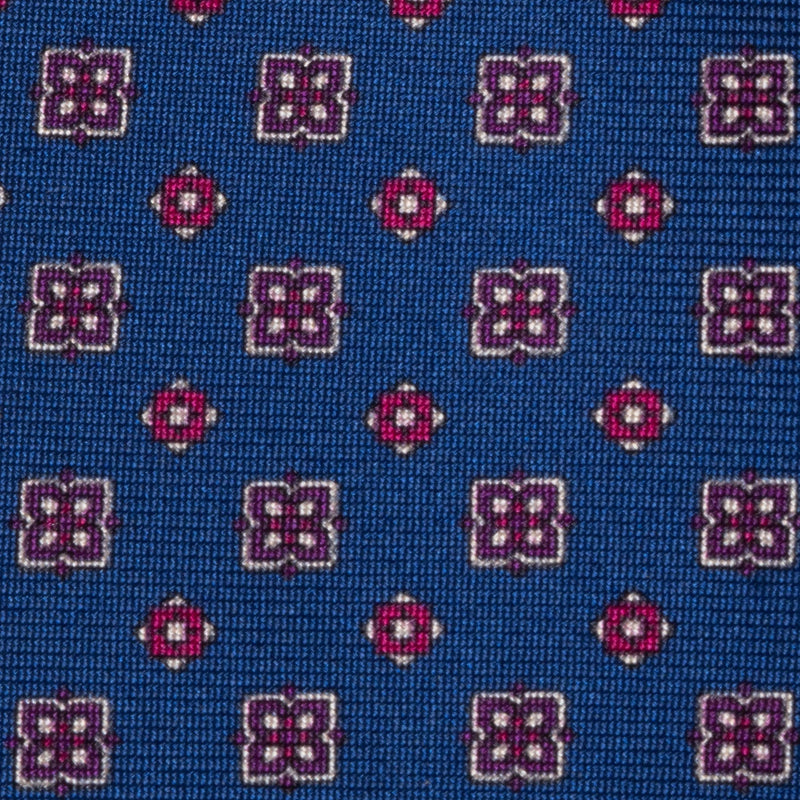 Close-up of royal blue silk tie showcasing intricate floral foulard print.