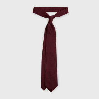 Burgundy grenadine tie made from premium Italian silk, displayed knotted.