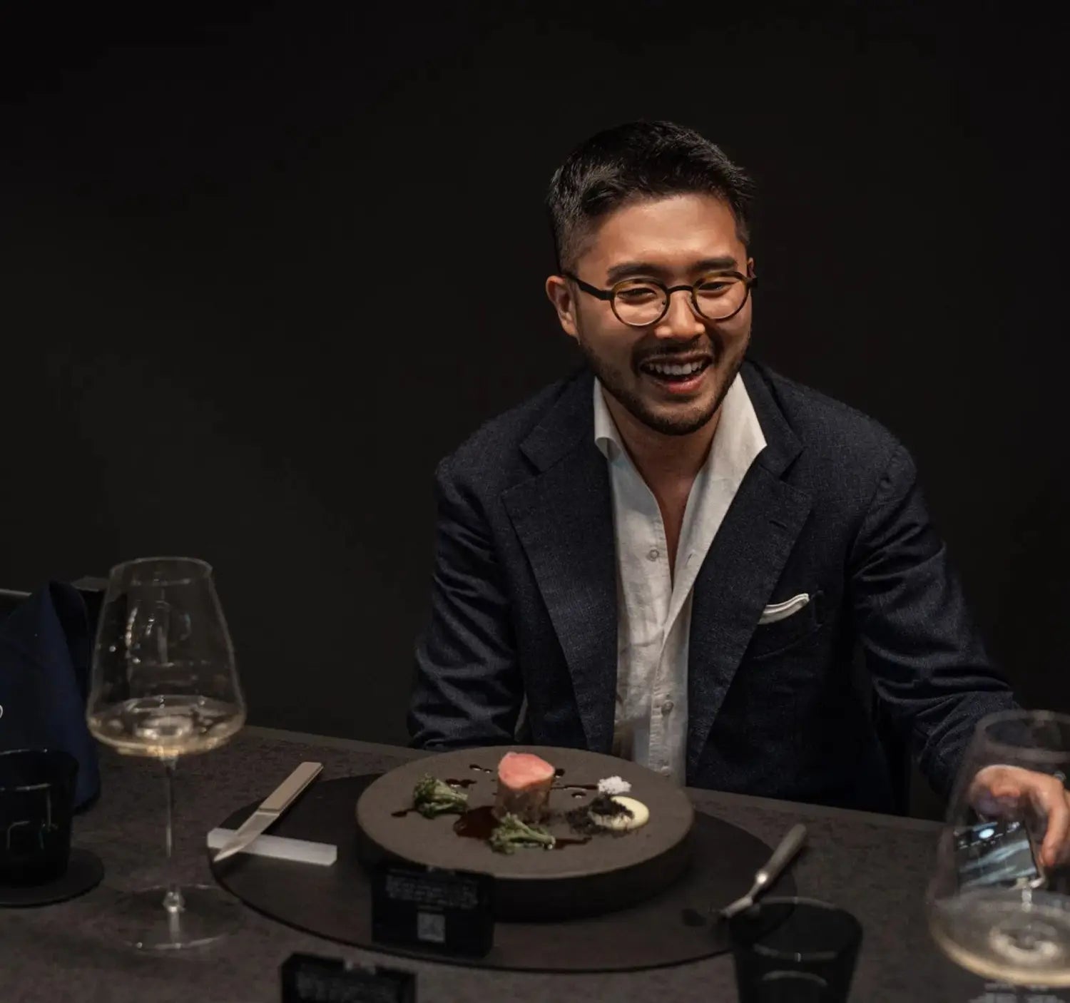 Smiling man in industry dress with a plated meal, showcasing confident conference outfit