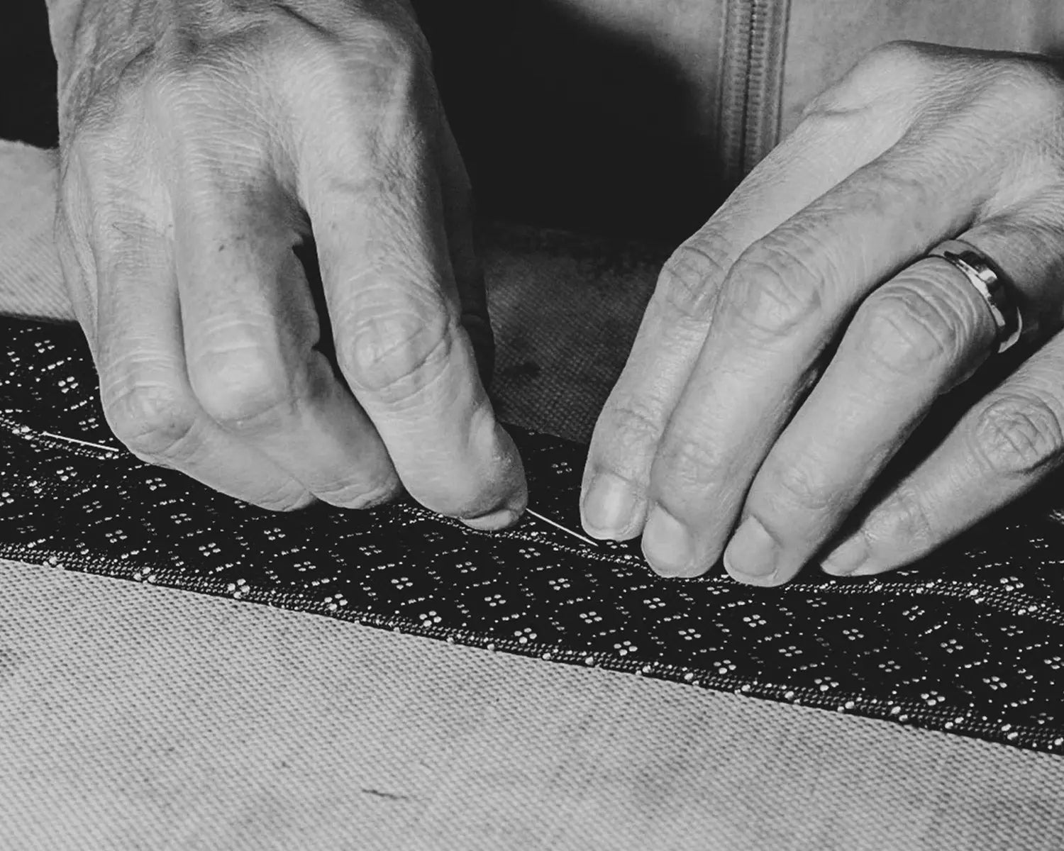 Hands sewing patterned fabric to spot high-quality clothes in fashion craftsmanship