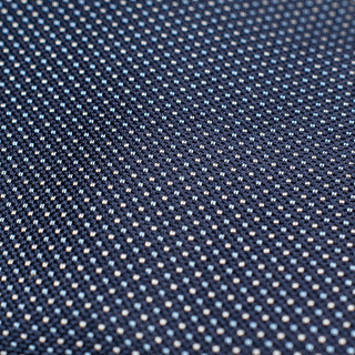 Detailed close-up of the micro pattern on the navy blue silk tie.