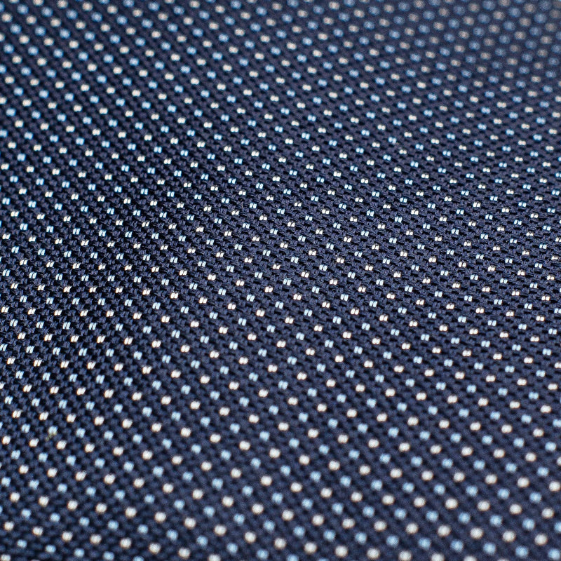 Detailed close-up of the micro pattern on the navy blue silk tie.