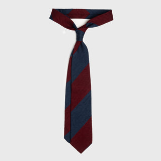 Navy blue and burgundy striped shantung tie tied in a classic knot, showcasing bold design.