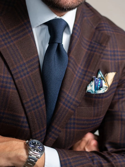 Navy Grenadine Tie Paired with a White shirt and Patterned Brown Jacket