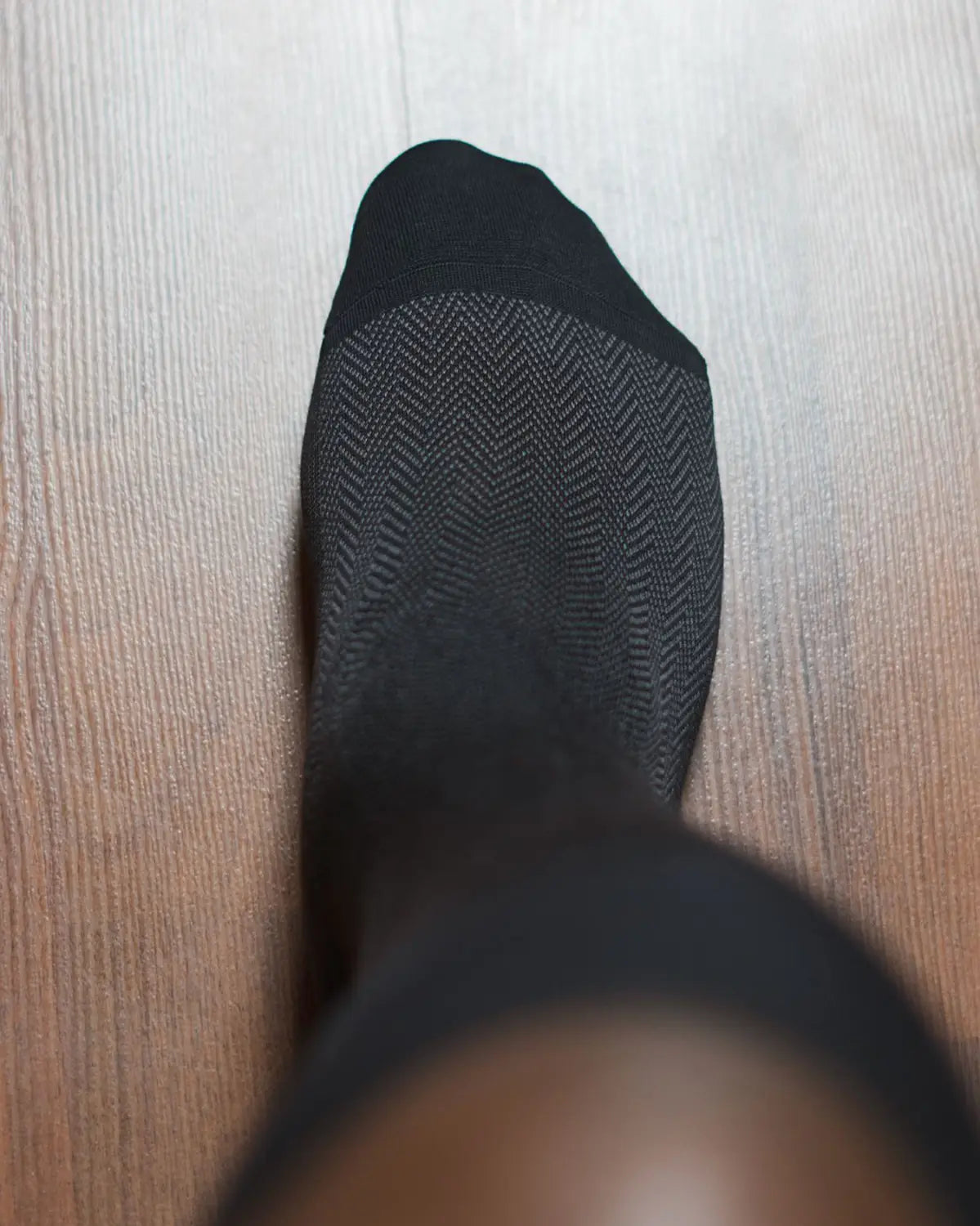 Black dress sock with herringbone pattern showcasing the best sock material for spring