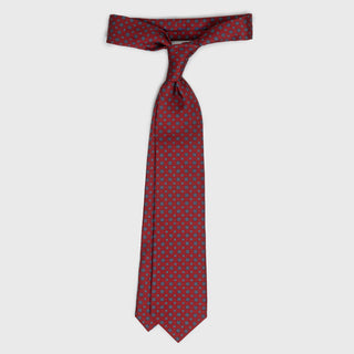 Red floral foulard printed silk tie displayed in a loosely tied knot.