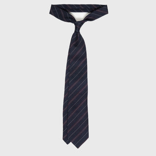 Red and white striped blue grenadine tie tied in a classic knot.