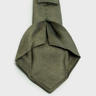 Close-up of the sage green silk tie's intricate six-fold construction.