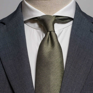 Sage green silk tie styled with a white shirt and gray suit for a formal look.