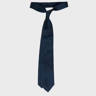 Solid dark blue silk tie tied in a classic knot, showcasing its elegant drape.