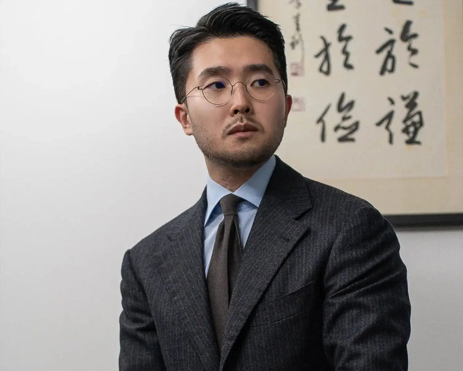 Man in suit and glasses showcasing elegant shirt collar styles for timeless fashion
