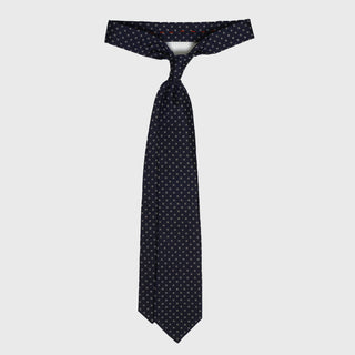 White ringed deep blue silk tie tied in a classic knot, highlighting its six-fold craftsmanship.