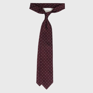 White dotted deep burgundy grenadine silk tie with intricate pattern.