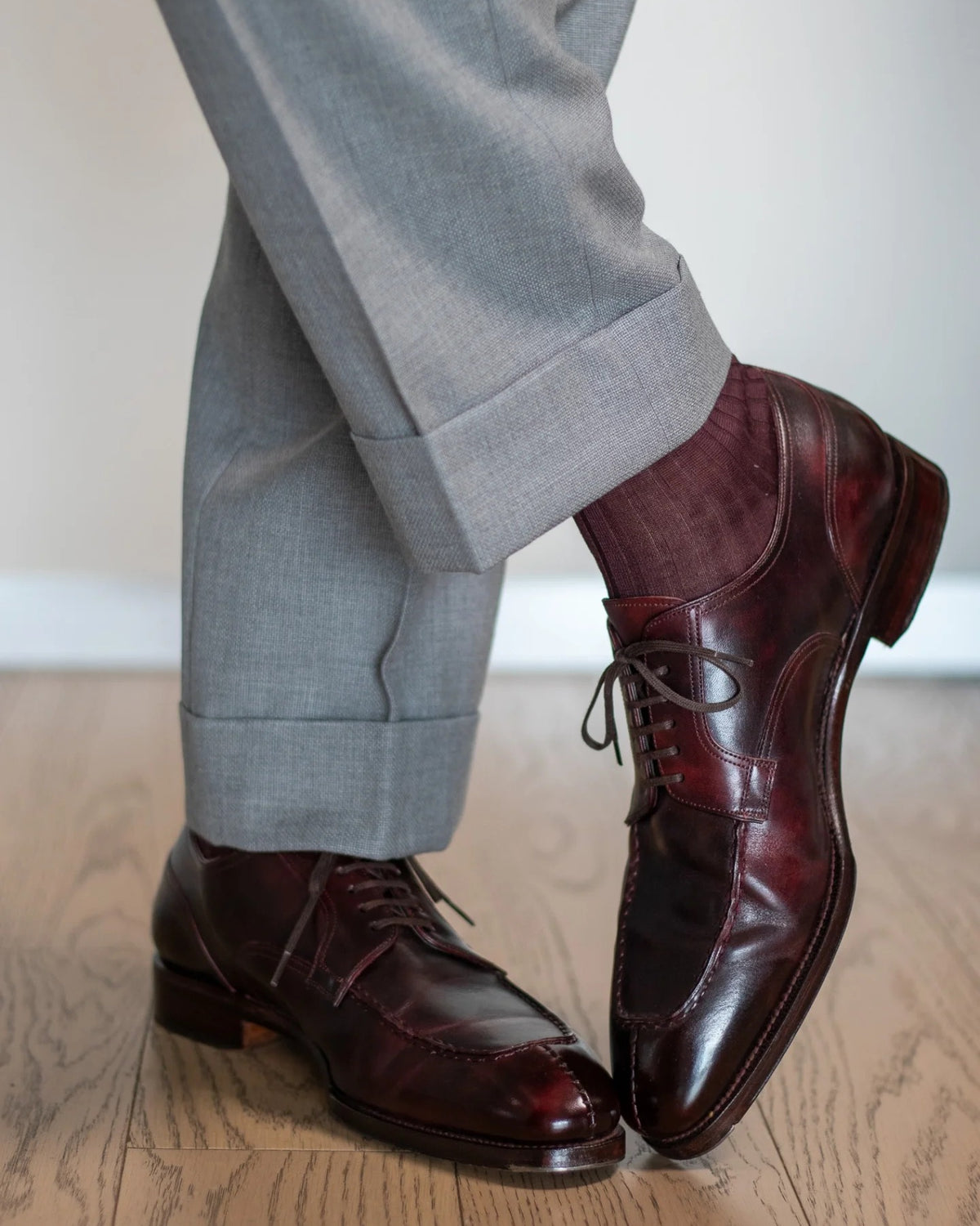 Burgundy dress socks worn with cuffed grey trousers and oxblood split-toe shoes