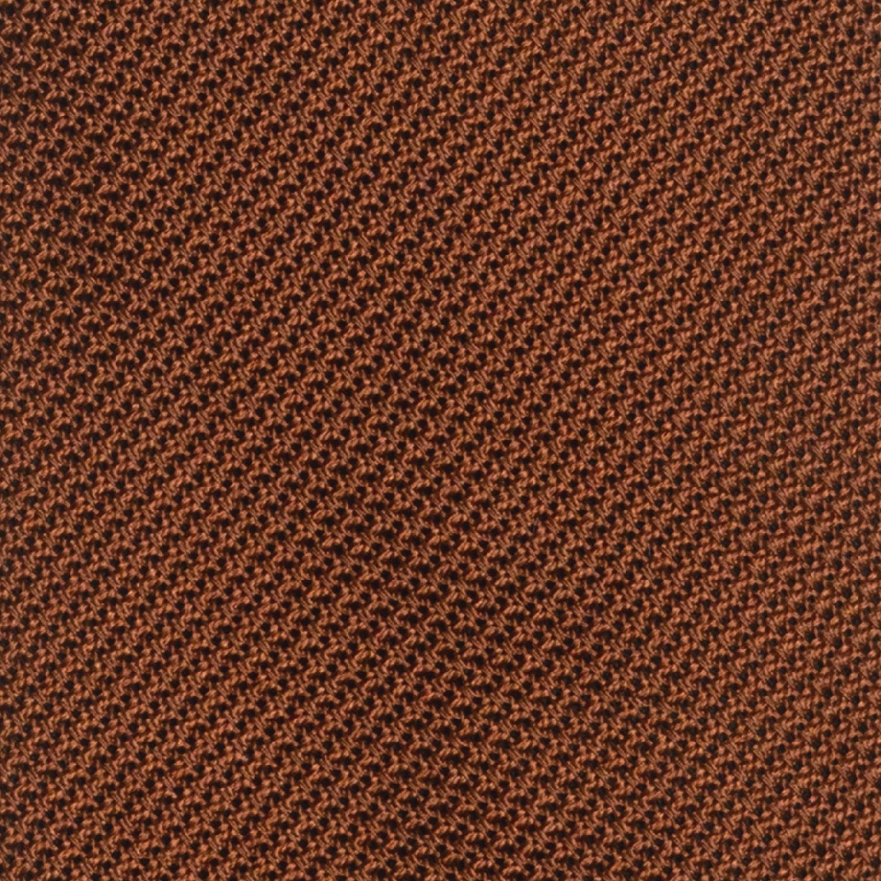 Close-up of burnt orange grenadine tie's intricate textured weave.