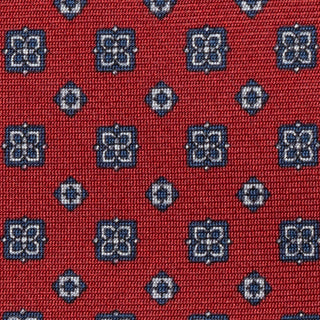 Close-up of blue floral foulard pattern on deep red silk fabric.
