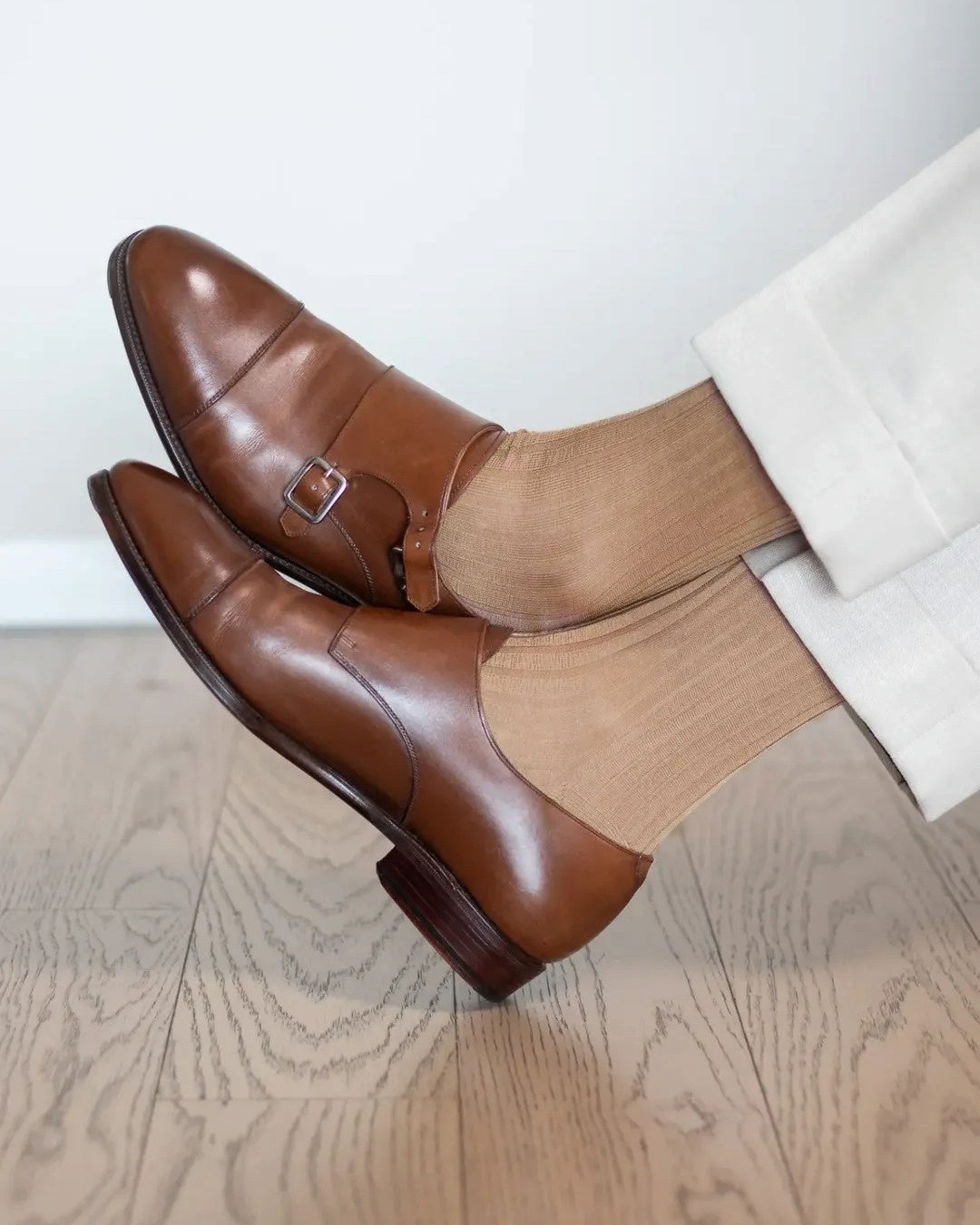 Light brown over-the-calf dress socks with cream trousers and brown monk strap shoes