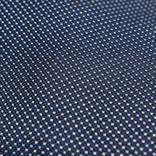 Detailed close-up of the micro pattern on the navy blue silk tie.