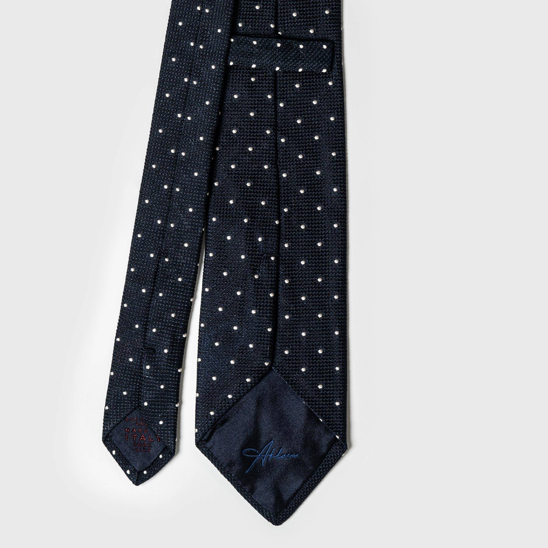 Back view of navy dotted grenadine tie with detailed stitching and label.