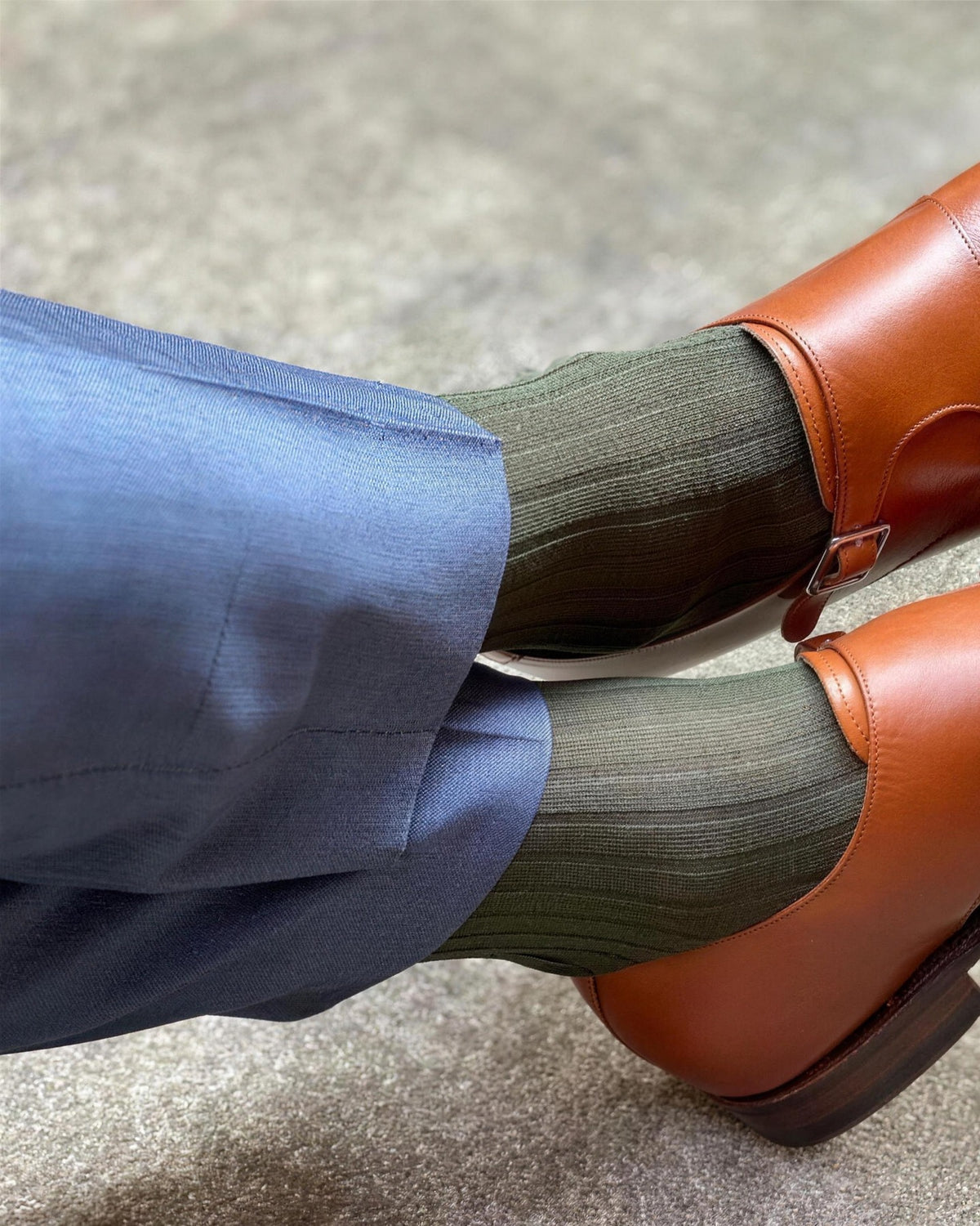 Olive green over-the-calf dress socks with blue trousers and tan double monk straps
