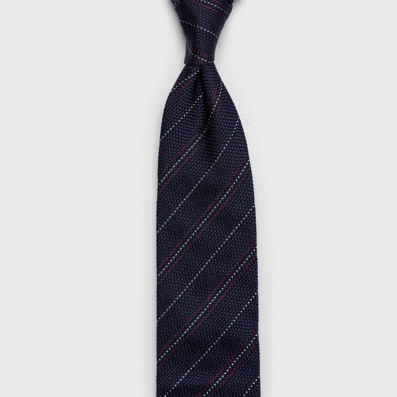 Red and white striped blue grenadine tie shown in a vertical view.