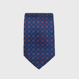 Royal blue silk tie with red and white floral foulard print, folded neatly.