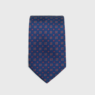 Royal blue silk tie with red and white floral foulard print, folded neatly.
