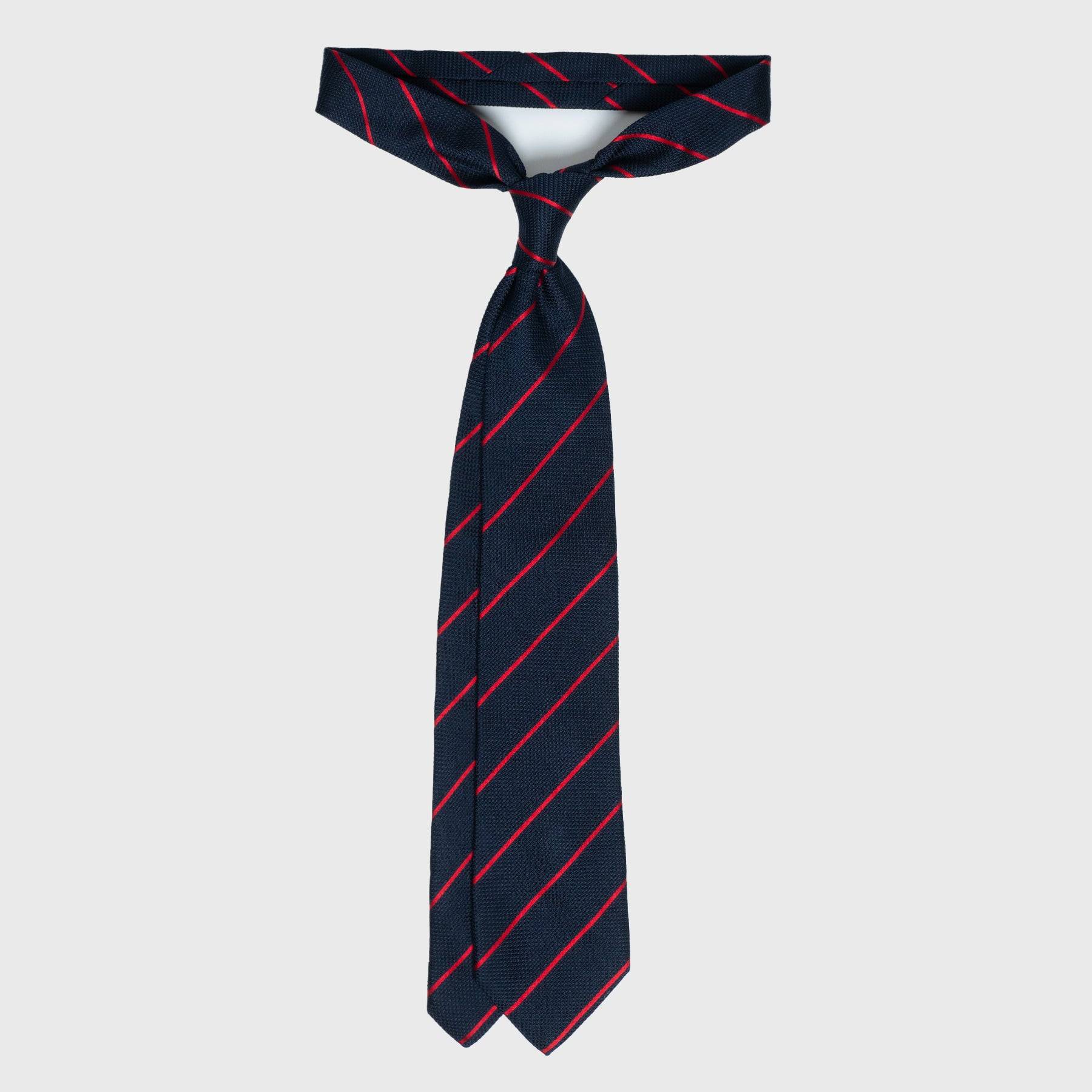 Full view of smooth red striped blue grenadine tie, untied and displayed.