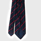 Backside of smooth red striped blue grenadine tie showcasing detailed stitching.