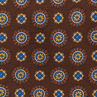 Close-up of medallion foulard pattern on brown silk tie, showcasing intricate design.