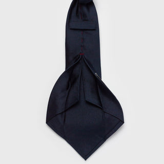 Back view of solid dark blue silk tie highlighting six-fold craftsmanship.