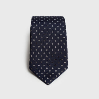 White ringed deep blue silk tie folded neatly, showcasing its elegant pattern.