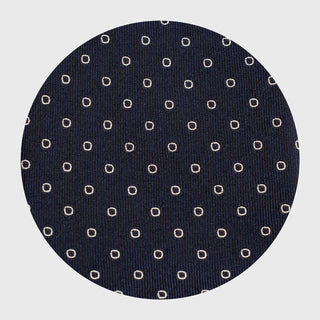 Detailed view of the white ring pattern on the deep blue silk tie fabric.